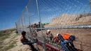 Seorang anak melihat pekerja dari Amerika Serikat saat membangun dinding perbatasan AS-Meksiko di Sunland Park, AS (09/9). Dinding perbatasan dibangun karena diduga sebagai pintu masuk imigran ilegal asal Mexico ke wilayah AS.(REUTERS/Jose Luis Gonzalez)