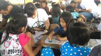 Setiap akhir pekan, sekelompok anak muda ini merelakan waktu mereka untuk mengajar anak-anak usia sekolah di Kompleks Pasar Bersehati Manado. (Liputan6.com/Yoseph Ikanubun)