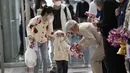 Seorang pejabat Thailand memberikan karangan bunga kepada turis China setibanya di Bandara Internasional Suvarnabhumi di provinsi Samut Prakarn, Senin (9/1/2023). Wisatawan China sekitar sepertiga dari jumlah total turis yang mengunjungi Thailand sebelum pandemi covid-19, dan pihak berwenang berharap mereka dapat membantu memulihkan industri pariwisata yang menguntungkan. (AP Photo/Sakchai Lalit)