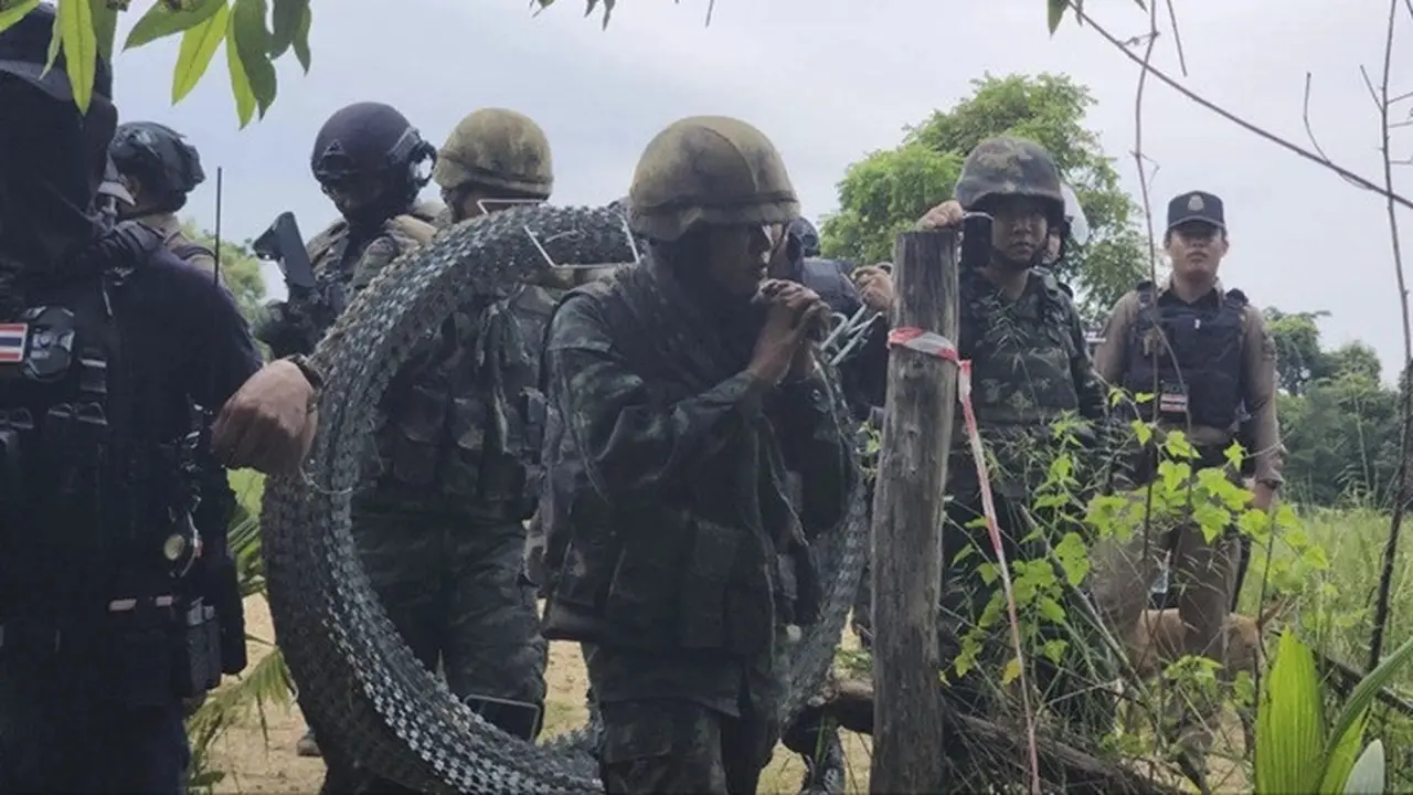 Foto yang dirilis oleh Agence Kampuchea Press (AKP) menunjukkan tentara Thailand membawa kawat berduri di Desa Prey Chan, di sepanjang perbatasan yang disengketakan dengan Kamboja, Rabu (17/9/2025).