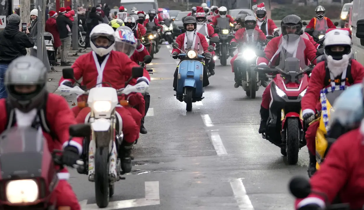 Pengendara sepeda motor yang mengenakan kostum Sinterklas mengendarai motor mereka selama parade Sinterklas di Beograd, Serbia, Minggu (26/12/2021). Mereka melakukan konvoi menuju rumah sakit anak-anak untuk membagikan mainan hadiah Natal kepada pasien di sana. (AP Photo/Darko Vojinovic)