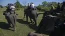 Turis menunggangi gajah di suaka margasatwa Pobitora, pinggiran Gauhati, India, Selasa (10/11/2020). Suaka yang terkenal dengan populasi badak bercula satu di India tersebut dibuka kembali untuk wisatawan setelah ditutup selama lebih dari 6 bulan akibat pandemi corona. (AP Photo/Anupam Nath)