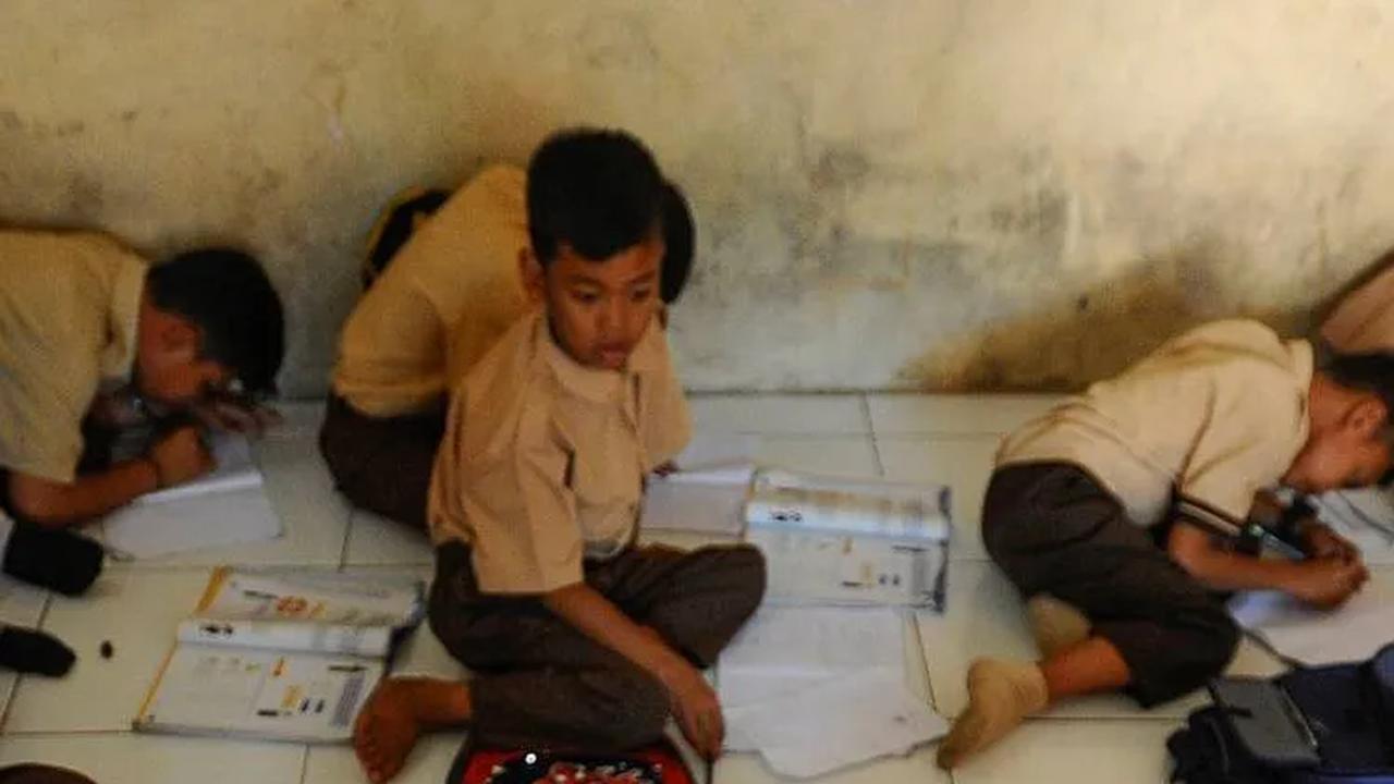 Kegiatan Belajar Mengajar (KBM) dilakukan dengan kondisi tanpa meja dan kursi di sekolah.