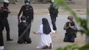 Suster Ann Rose Nu Tawng, biarawati Myanmar berlutut memohon kepada polisi untuk tidak menyakiti pengunjuk rasa di tengah tindakan keras terhadap demonstrasi menentang kudeta militer di Myitkyina di negara bagian Kachin Myanmar (8/3/2021). (Handout/Myitkyina News Journal/AFP)