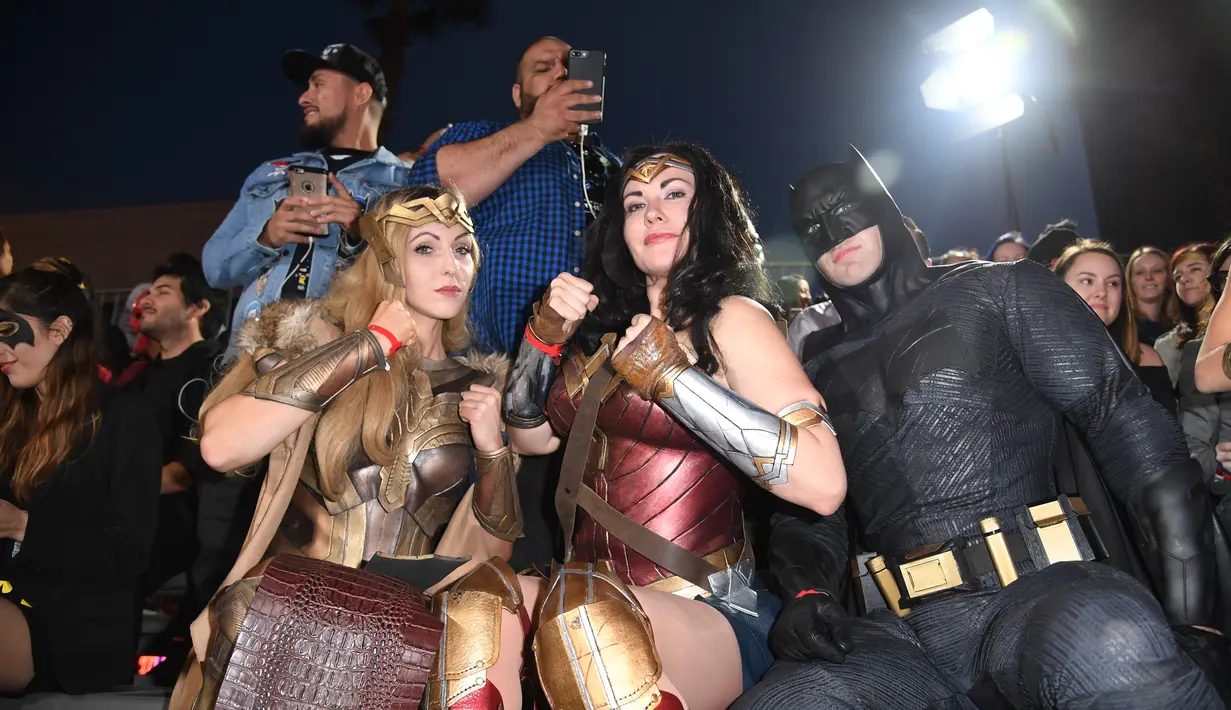 Penggemar mengenakan kostum Batman dan Wonder Woman saat menghadiri pemutaran perdana film Justice League di Dolby Theatre di Hollywood, California (13/11). (AFP Photo/Robyn Beck)