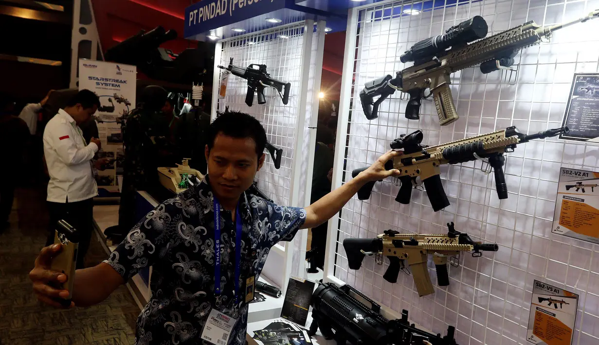 Pengunjung berswafoto saat mengunjungi Indo Defence 2018 Expo and Forum di JIExpo Kemayoran, Jakarta, Rabu (9/11). Pameran ini menjadi ajang promosi bisnis dan teknologi bagi industri pertahanan Indonesia dan dunia. (Liputan6.com/JohanTallo)
