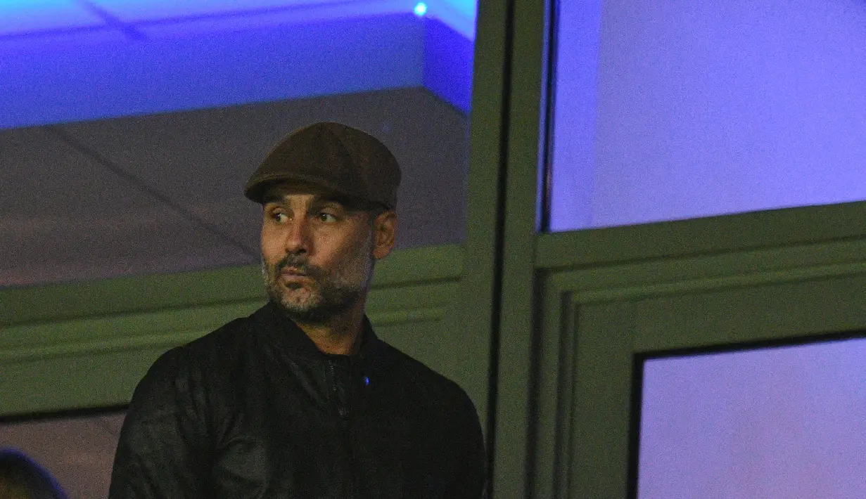 Pelatih Manchester City, Pep Guardiola menuju tribun penonton untuk melihat tim asuhannya melawan Olympique Lyon pada Grup F Liga Champions di Stadion Etihad, Rabu (19/9).  Guardiola duduk di bangku penonton karena sedang menjalani sanksi (AFP/Oli SCARFF)