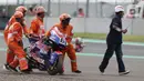 Marshal mendorong motor pembalap Cameroon Beaubier saat kualifikasi Moto2 di Pertamina Mandalika International Street Sirkuit, Lombok, NTB, Sabtu (19/3/2022). Trackside Marshal bertanggungjawab memastikan lintasan bebas dari hal berpotensi membahayakan pembalap. (Liputan6.com/Helmi Fithriansyah)