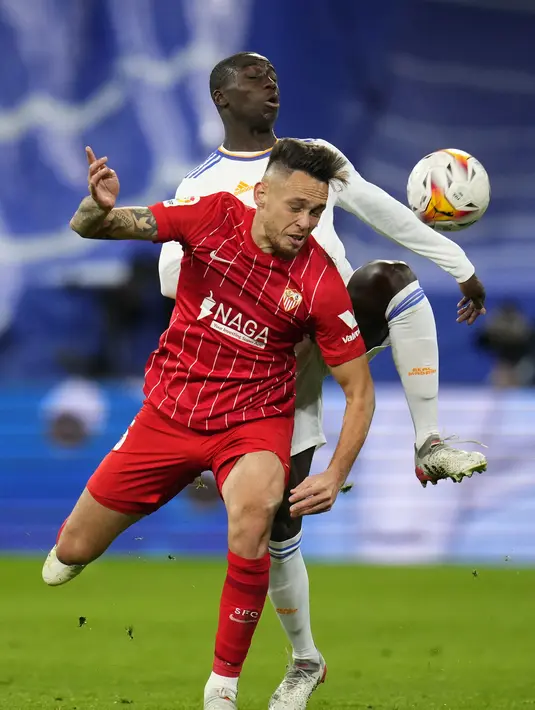 Bek Real Madrid, Ferland Mendy berebut bola dengan penyerang Sevilla pada pertandingan lanjutan La Liga Spanyol di di stadion Bernabeu, Madrid, Spanyol, Senin (29/11/2021). Real Madrid menang tipis atas Sevilla 2-1. (AP Photo/Manu Fernandez)