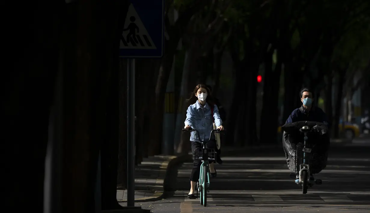 <p>Orang-orang yang memakai masker berkendara di sepanjang jalan di Beijing, Rabu (11/5/2022). Shanghai pada Rabu menegaskan kembali akan mempertahankan pendekatan &ldquo;nol-COVID&rdquo; pengendalian pandemi, sehari setelah kepala Organisasi Kesehatan Dunia (WHO) menyatakan kebijakan itu tidak berkelanjutan dan mendesak China mengubah strategi. (AP Photo/Mark Schiefelbein)</p>