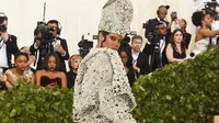 Penyanyi Rihanna berpose setibanya pada pagelaran Met Gala 2018 di Museum Seni Metropolitan New York, Senin (7/5). Rihanna mengenakan gaun pendek strapless yang seksi dilengkapi jubah berukirkan kristal dan mutiara. (Jamie McCarthy/Getty Images/AFP)