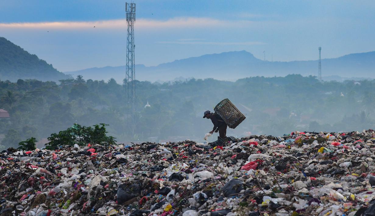 Warga yang berprofesi sebagai pemulung mengumpulkan sampah plastik dengan latar belakang Gunung Gede-Pangrango di Tempat Pembuangan Akhir Galuga, Bogor, Kamis (6/11/2025). Capping bertujuan menghindari air hujan masuk ke sampah tercampur, sehingga menghasilkan air lindi yang mencemari lingkungan. (merdeka.com/Arie Basuki)