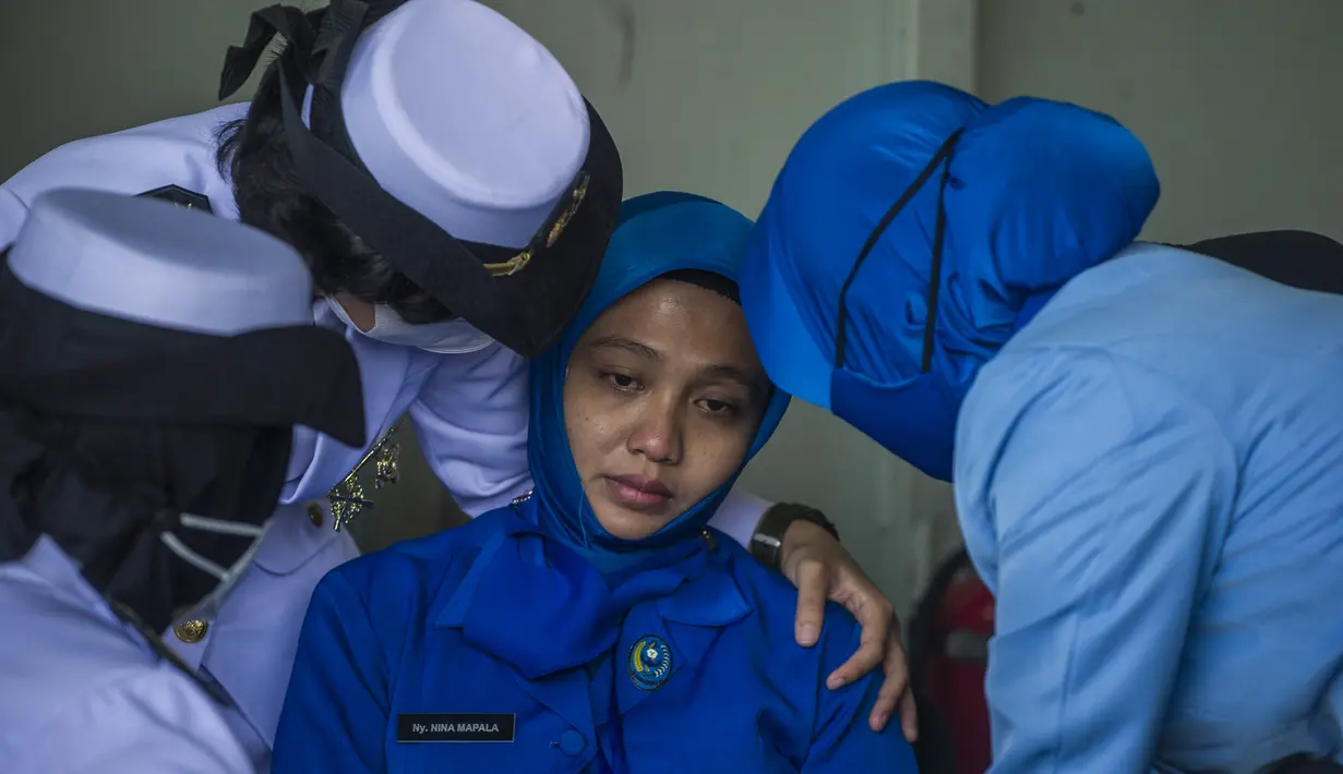 Personel militer menghibur awak KRI Nanggala 402 saat menggelar Tabur Bunga dari geladak Helly KRI Dr Soeharso-990 di perairan utara pulau Bali, Jumat (30/4/2021). Kegiatan tabur bunga digelar sebagai penghormatan terahir bagi awak KRI Nanggala 402 yang gugur dalam medan tugas. (Juni Kriswanto/AFP)