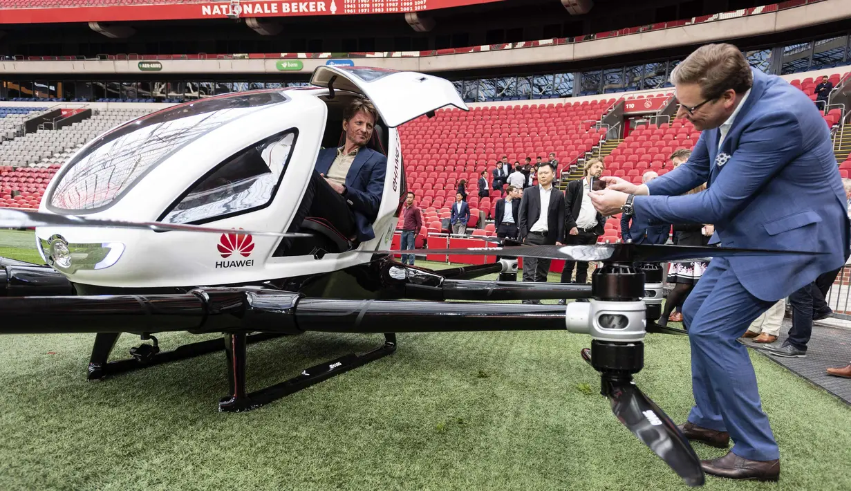 Pangeran Belanda Pieter Christiaan (kiri) duduk di taksi pesawat tak berawak saat uji coba penerbangan di Amsterdam Arena, (16/4). Taksi pesawat tak berawak ini dapat membawa dua orang hingga 210 Kilogram. (AFP Photo/ANP/Evert Elzinga)