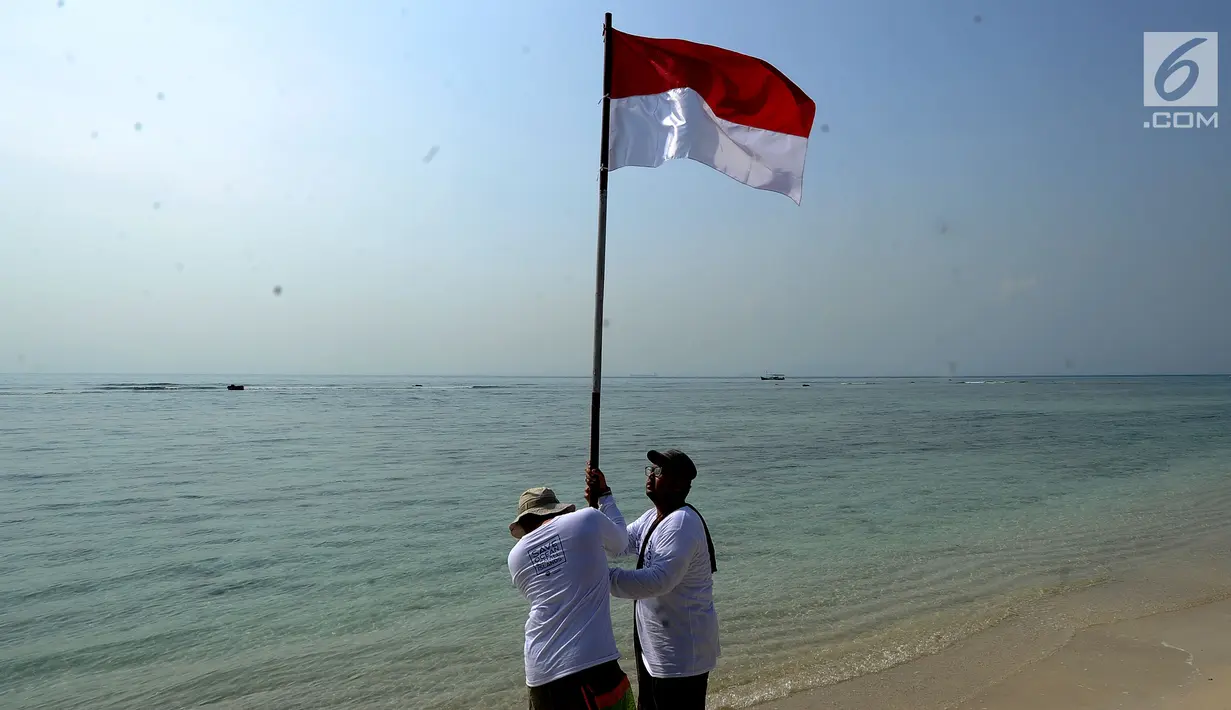 Aktivis Yayasan Kehati Jakarta  bersiap melakukan upacara bendera menghadap laut dalam rangka HUT ke-74 RI di Pulau Sangiang, Banten, Minggu (18/8/2019). Dalam kegiatan ini juga dilakukan akbir bersih pantai dengan memungut sampah-sampah di seputaran pantai. (merdeka.com/Arie Basuki)