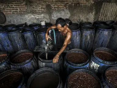 Pekerja membuat alkohol tradisional di industri rumahan Desa Bekonang, Kecamatan Mojolaban, Kabupaten Sukoharjo, Jawa Tengah, Rabu (18/11/2020). Minuman dengan nama Ciu Bekonang tersebut dibuat dari hasil penyulingan tetes tebu yang telah difermentasi. (Liputan6.com/Johan Tallo)