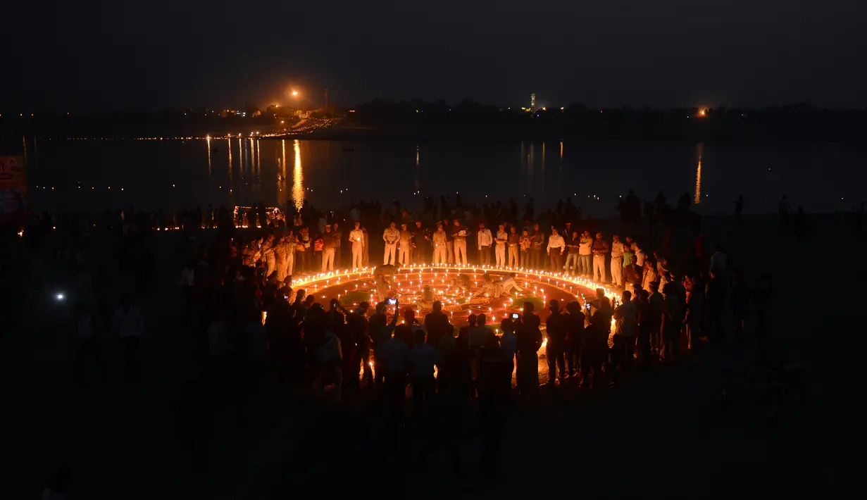 Polisi India menyalakan lilin di Sangam saat festival 'Dev Deepawali,' atau festival cahaya, di Allahabad, Rabu (25/11).  Festival ini adalah perayaan atas kemenangan kebaikan atas kejahatan. (AFP PHOTO/Sanjay Kanojia)