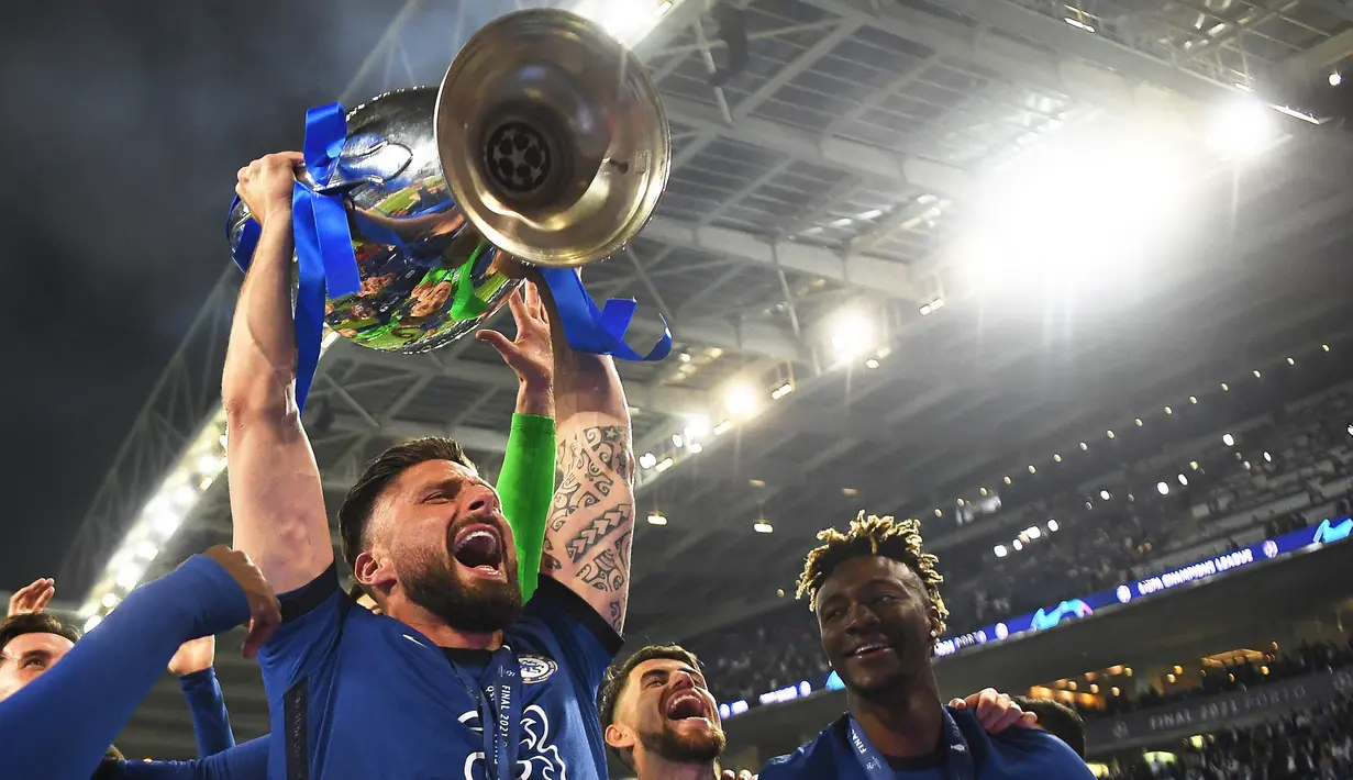 Selebrasi striker Chelsea, Olivier Giroud bersama trofi Liga Champions setelah laga final Liga Champions 2020/2021 menghadapi Manchester City di Dragao Stadium, Porto (29/5/2021). Bersama Chelsea pada musim 2020/2021, Olivier Giroud hanya tampil satu kali pada leg kedua semifinal Liga Champions menghadapi Real Madrid walau hanya satu menit. Chelsea pun lolos ke final hingga akhirnya juara usai mengalahkan Man City di mana Olivier Giroud hanya duduk di bangku cadangan. (AFP/Pool/David Ramos)