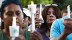 Seorang wanita berdoa sambil memegang lilin  saat menghadiri acara untuk korban penembakan brutal di festival kuliner Gilroy Garlic di Gilroy, California (29/7/2019). Tiga orang tewas dan sedikitnya puluhan orang terluka akibat kejadian tersebut. (AFP Photo/Mario Tama)