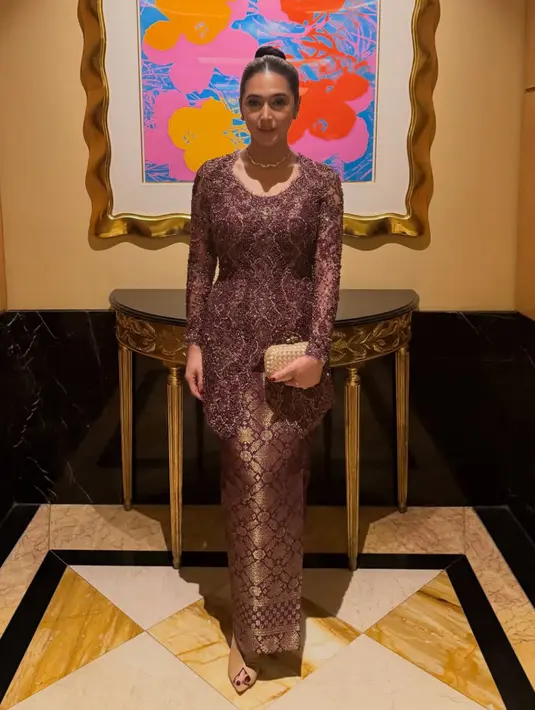 Nabila Syakieb tampil mengenakan kebaya berpayet ungu dipadukan bawahan kain songket warna gold keunguan. Serta mengenakan kalung tampa liontin. [@nsyakieb85]