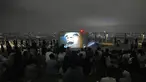 Pengunjung menonton film di rooftop dek observasi Shibuya Sky di Tokyo, Sabtu (9/10/2021). seminggu setelah Jepang sepenuhnya keluar dari keadaan darurat virus corona untuk pertama kalinya dalam lebih dari enam bulan. (AP Photo / Kiichiro Sato)