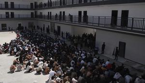 Warga&nbsp;China, Vietnam, dan Ethiopia, yang diyakini telah diperdagangkan dan dipaksa bekerja di pusat-pusat penipuan, duduk dengan wajah tertutup saat ditahan setelah dibebaskan dari Distrik Myawaddy, Myanmar, Rabu (26/2/2025). (Dok. AP/Thanaphon Wuttison)