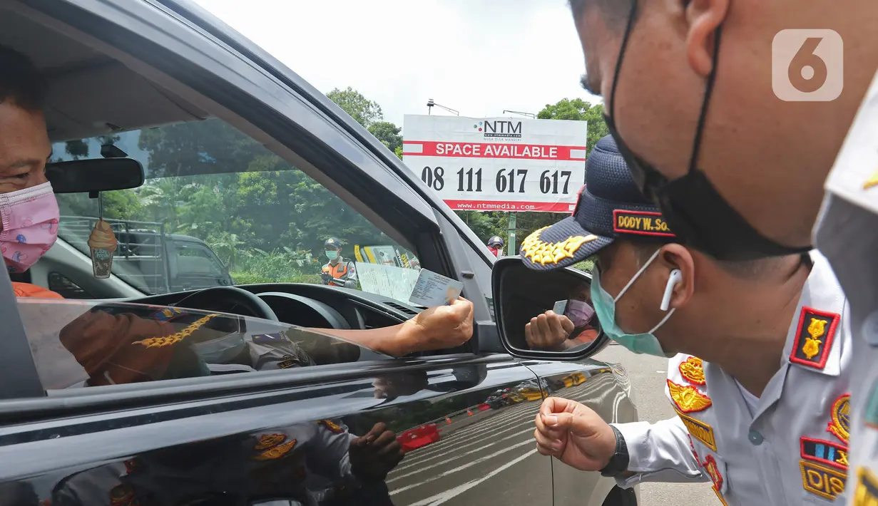 Petugas memeriksa pengendara mobil saat pemberlakuan aturan ganjil-genap di pos sekat Gerbang Tol Bogor, Kota Bogor, Jawa Barat, Sabtu (6/2/2021). Pemerintah Kota Bogor mulai menerapkan aturan ganjil-genap di setiap akhir pekan bagi kendaraan roda dua maupun empat. (Liputan6.com/Herman Zakharia)