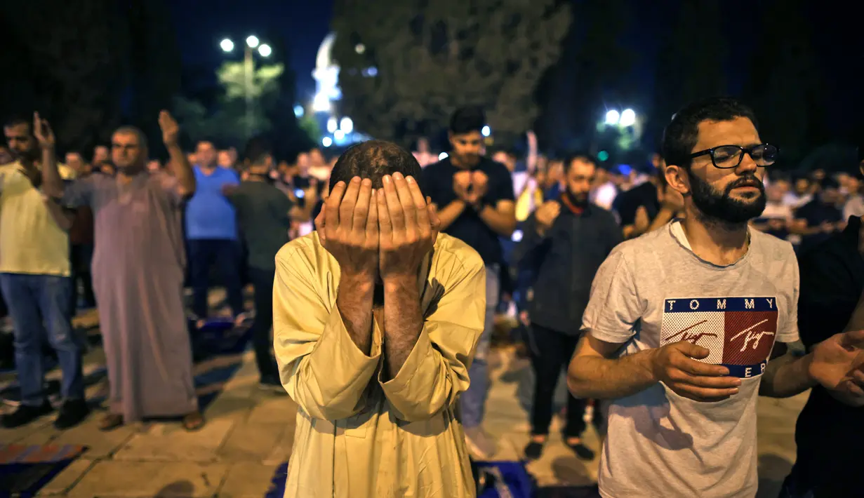Seorang muslim Palestina khusyuk berdoa saat berburu malam Lailatul Qadar di luar Kubah Batu (Dome of the Rock) di kompleks Masjid Al-Aqsa di Yerusalem (8/5/2021). (AFP/Ahmad Gharabli)