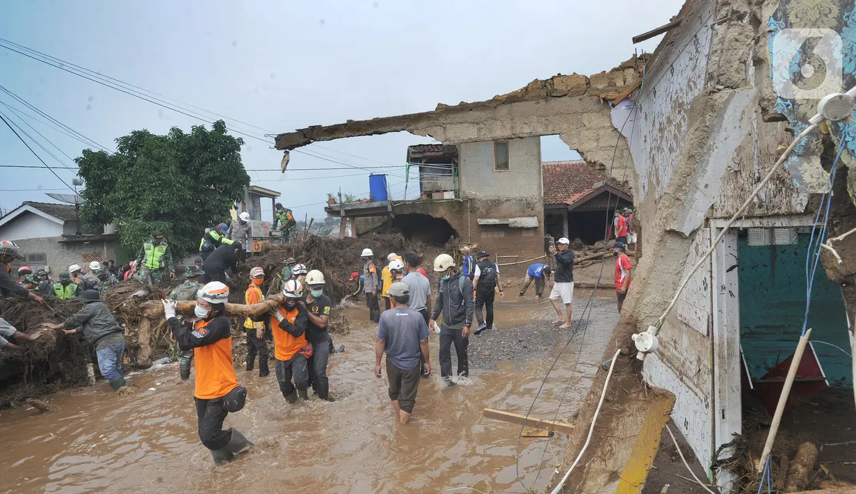 Tim SAR gabungan TNI, Polri, dan relawan membersihkan material longsor usai banjir bandang menerjang Kampung Cibuntu, Desa Pasawahan, Kecamatan Cicurug, Sukabumi, Selasa (22/9/2020). Banjir mengakibatkan puluhan bangunan rusak berat, 12 rumah hanyut, dan dua korban hilang. (merdeka.com/Arie Basuki)