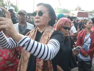 Aktivis Ratna Sarumpaet mengabadikan gambar saat penertiban pemukiman penduduk di kawasan Rawajati, Jakarta, Kamis (1/9). Keberadaan Ratna di lokasi tersebut guna membantu mediasi warga yang rumahnya dieksekusi petugas. (Liputan6.com/Immanuel Antonius)