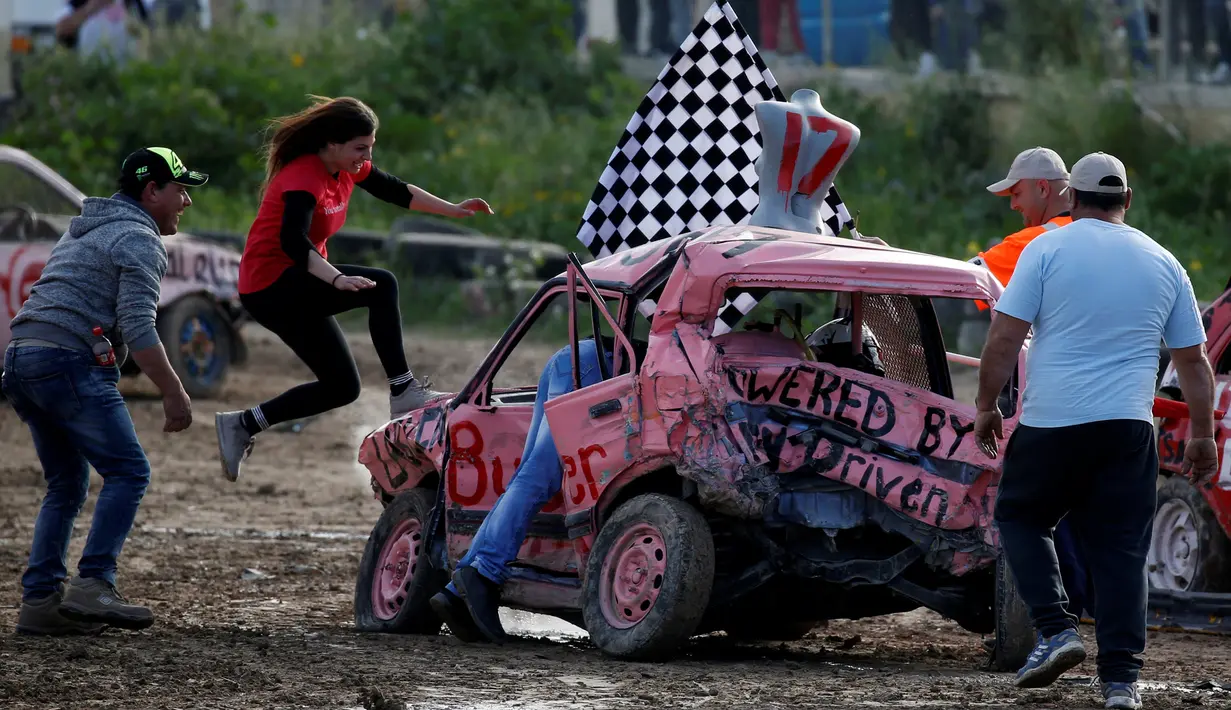 dari rekan-rekannya saat memenangkan kompetisi saling menghancurkan mobil 'Demolition Derby' wanita pertama di Ta 'Qali, Malta, 10 Maret 2019. (REUTERS/Darrin Zammit Lupi)