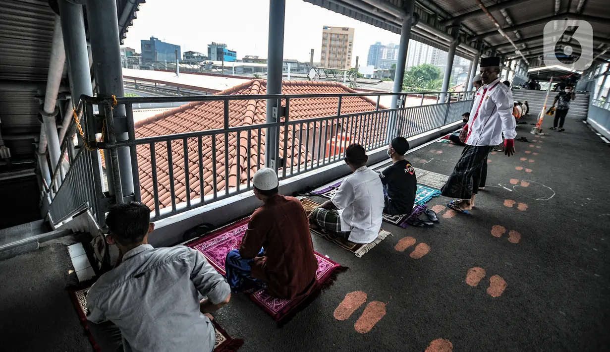 Umat Islam mendengarkan ceramah saat menunaikan salat Jumat di Stasiun Kampung Bandan, Jakarta, Jumat (7/5/2021). Sebagian jemaah menjadikan peron stasiun sebagai tempat salat dan sebagian lain berada di tangga serta jembatan penyeberangan. (merdeka.com/Iqbal S. Nugroho)