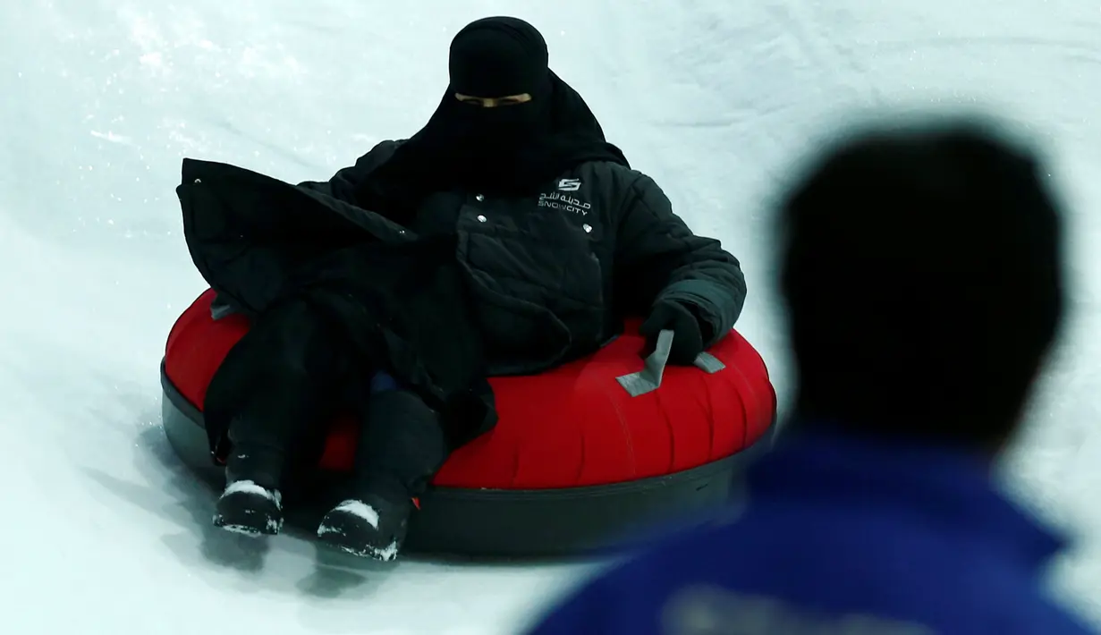 Seorang wanita bercadar berseluncur di atas salju di wahana Snow City di Mall Al Othaim, Riyadh, Arab Saudi, (26/7). Warga Riyadh dapat menikmati asyiknya bermain di salju buatan. (REUTERS/Faisal Al Nasser)