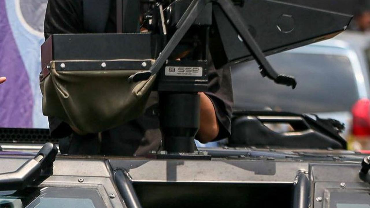 Salah seorang warga mencoba duduk di depan senjata rantis saat berfoto di atas kendaraan milik TNI saat pameran Alutsista di kawasan Monas, Jakarta, Minggu (24/9/2023).