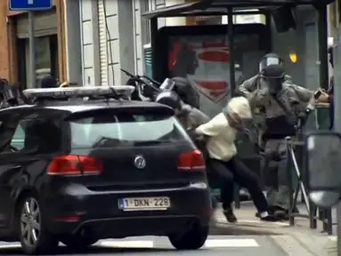 Polisi Belgia menangkap Salah Abdeslam, tersangka pelaku pemboman di Paris, di Molenbeek, Brussels, Belgia, (18/3). Abdeslam diamankan setelah tembak-menembak dengan petugas kepolisian di Brussels pada hari Jumat. (REUTERS/VTM)