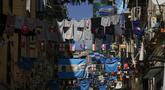Bendera tim sepak bola Napoli, jersey pemain, dan bendera Argentina dipajang di Quartieri Spagnoli (lingkungan Spanyol), di Naples, Italia, Jumat, 24 Maret 2023. (AP Photo/Alessandra Tarantino)