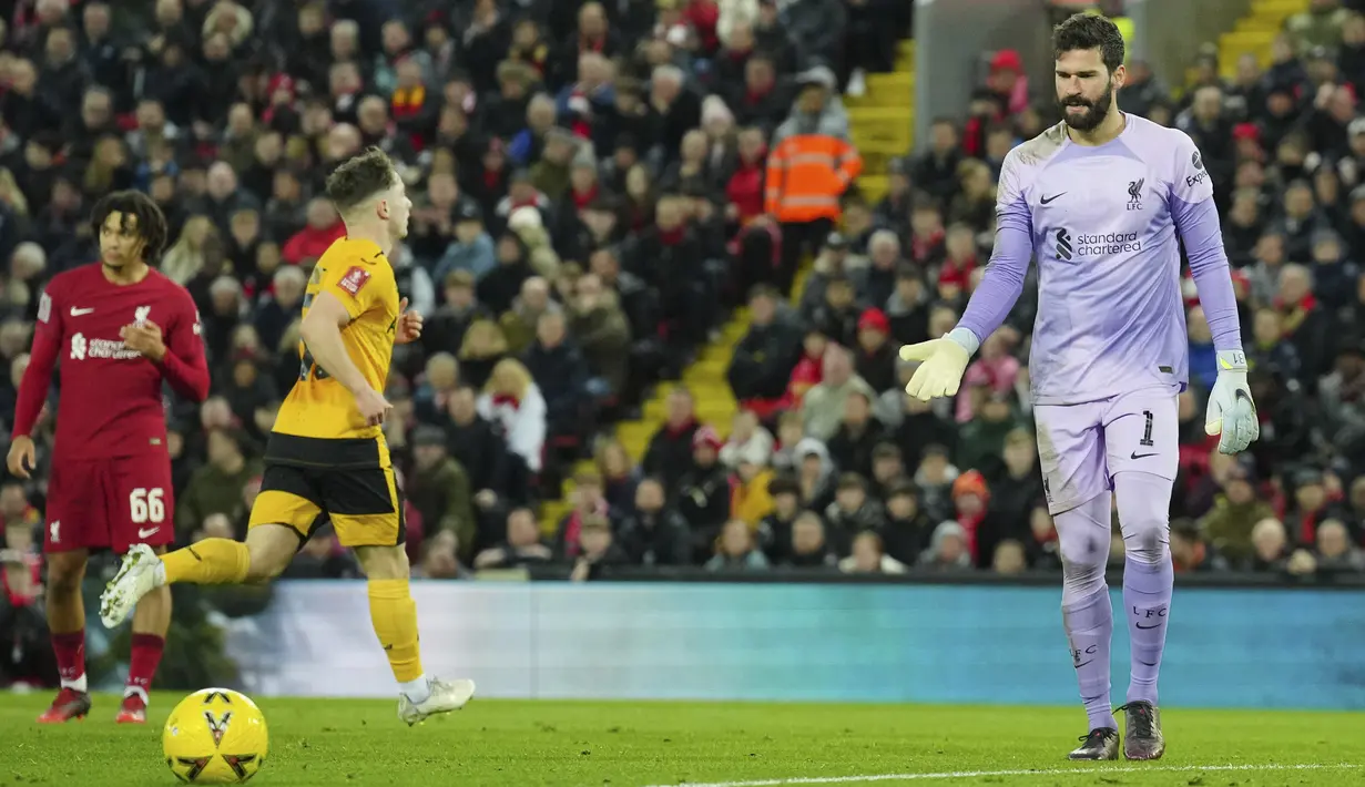 <p>Kiper Liverpool, Alisson bereaksi setelah kebobolan gol pembuka dari pemain Wolverhampton Wanderers Goncalo Guedes selama pertandingan putaran ketiga Piala FA di stadion Anfield, Inggris, Minggu (8/1/2023). Liverpool bermain imbang dengan Wolves dengan skor 2-2. (AP Photo/Jon Super)</p>