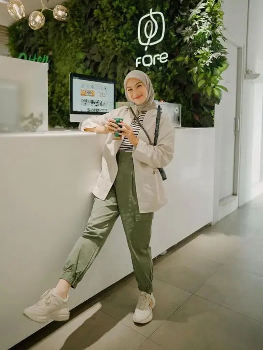 Cocok untuk outfit kuliah, kombinasikan kemeja dengan stripe t-shirt dan jogger pants warna hijau. Sepatu converse memperkuat kesan sporty nan kasual pada penampilanmu. (Instagram/indahadapuspita).