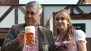 Pelatih Bayern Munchen, Carlo Ancelotti ditemani istrinya, Mariann Barrena McClay memegang cangkir bir saat mereka berpose selama festival bir Oktoberfest 2017 di Munich, Jerman (23/9). (AFP Photo/Christof Stache)