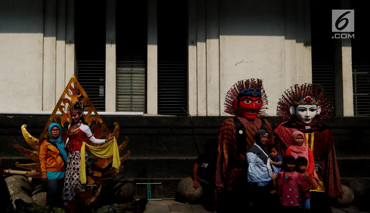 Pengunjung berfoto dengan manusia patung di kawasan Museum Fatahilah, Kota Tua, Jakarta, Selasa (20/11). Objek wisata sejarah Kota Tua menjadi salah satu tujuan warga Jakarta dan sekitarnya untuk mengisi libur Maulid Nabi 2018. (Liputan6.com/Johan Tallo)
