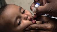 Ekspresi seorang anak saat diberikan vaksin polio oleh pekerja kesehatan di Lahore, Pakistan, (9/4). Pakistan meluncurkan vaksinasi polio baru, yang bertujuan agar 38,7 juta anak di bawah usia 5 tahun mendapatkan vaksin tersebut. (AP Photo/KM Chaudary)