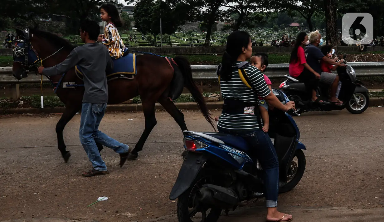 Seorang anak menaiki kuda di ruang kota Jalan Inpeksi Tanah Kusir, Jakarta, Senin (19/4/2021). Jalan Inpeksi Tanah Kusir ini menjadi salah satu tempat pilihan warga untuk menghabiskan waktu sembari menunggu berbuka puasa atau ngabuburit. (Liputan6.com/Johan Tallo)