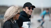 Presiden Prancis Emmanuel Macron dan istrinya Brigitte Macron berjalan di sepanjang pantai di Le Touquet, menjelang putaran kedua pemilihan presiden Prancis, Sabtu (23/4/2022). Emmanuel Macron berada di posisi terdepan untuk memenangkan pemilihan kembali Minggu, 24 April 2022 dalam&nbsp;Pilpres Prancis. (AP Photo/Thibault Camus)