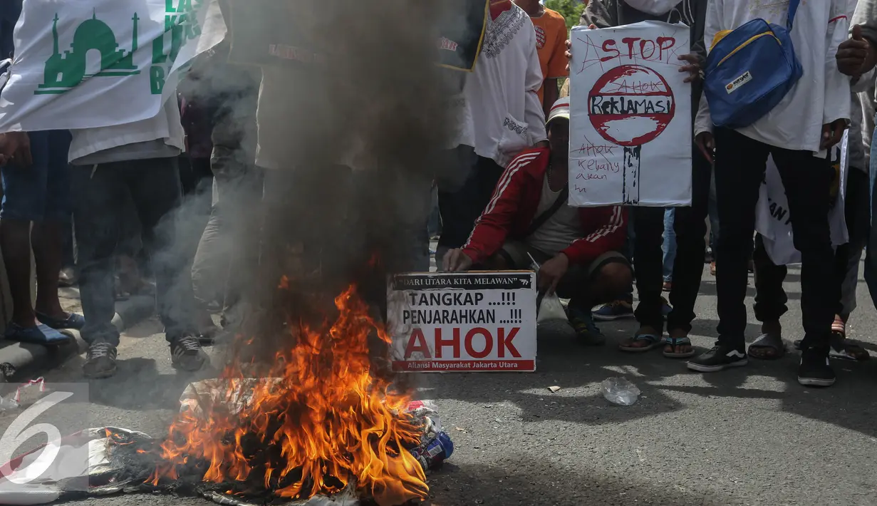 Warga Luar Batang membakar atribut demo saat aksi di depan gedung KPK, Jakarta, Selasa (3/5/2016). Mereka menuntut agar KPK menangkap Gubernur DKI Jakarta Basuki T Purnama (Ahok). (Liputan6.com/Faizal Fanani)