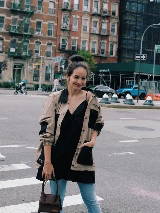 Berkunjung ke New York, street style Enzy Storia kali ini jatuh pada jaket dan dress hitam yang dipadu celana jeans. (Instagram/enzystoria).