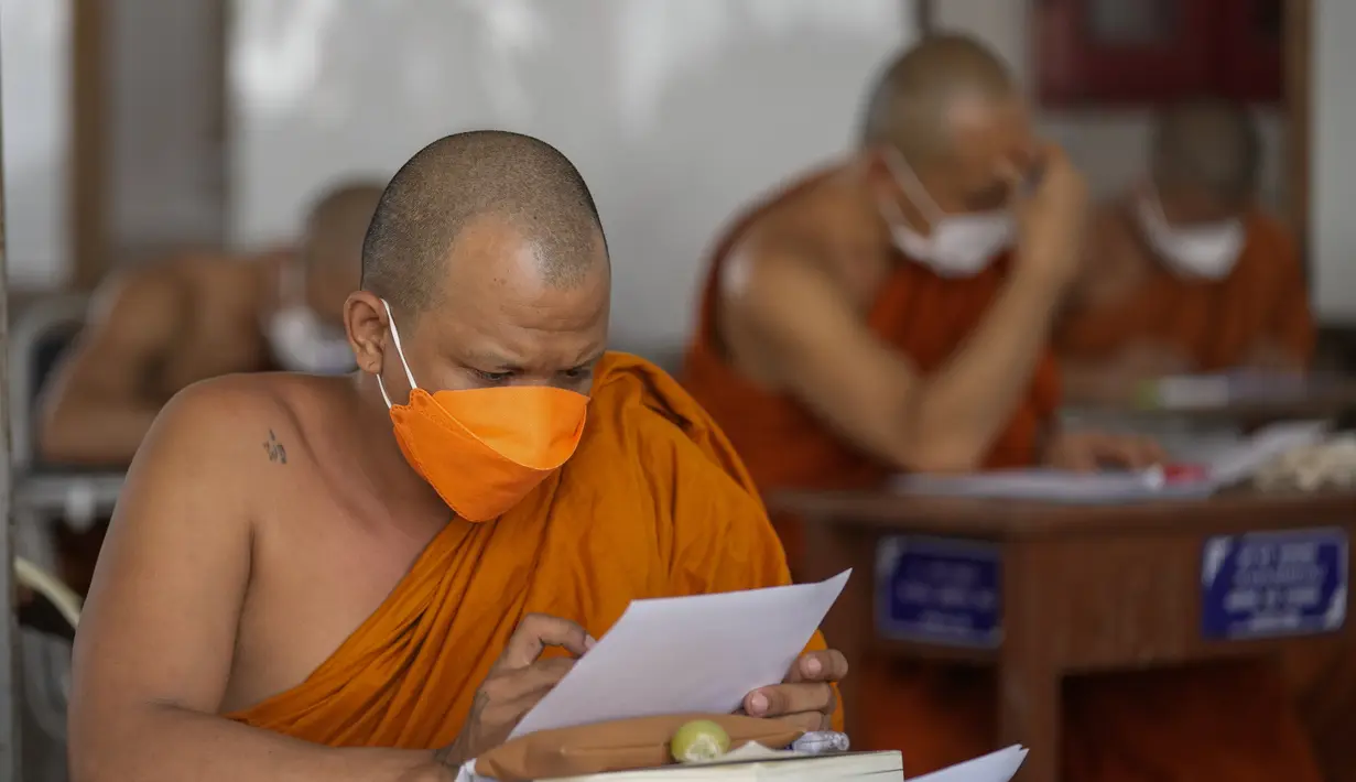 Seorang Biksu Buddha memakai masker untuk membantu melindungi diri dari virus corona, mengikuti tes bahasa Pali liturgi di Wat Molilokayaram di Bangkok, Thailand, Kamis (20/1/2022). (AP Photo/Sakchai Lalit)