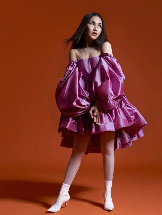 Menolak tua, beberapa penampilan photoshoot Ayu Ting Ting juga menarik untuk disimak. Off-the-shoulder dress berwarna ungu muda, berlengan balon dengan aksen ruffles di bagian rok ini membuat penampilan Ayu Ting Ting bak idol Korea yang masih remaja. Ia padukan dengan heels boots berwarna putih. Foto: Instagram.
