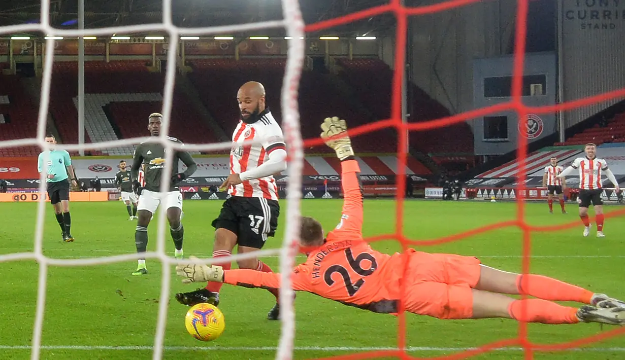 Striker Sheffield United, David McGoldrick, mencetak gol pertama ke gawang Manchester United yang dikawal Dean Henderson, dalam laga lanjutan Liga Inggris 2020/21 pekan ke-13 di Bramall Lane, Sheffield, Kamis (17/12/2020). Sheffield United kalah 2-3 dari Manchester United. (AFP/Peter Powell/Pool)