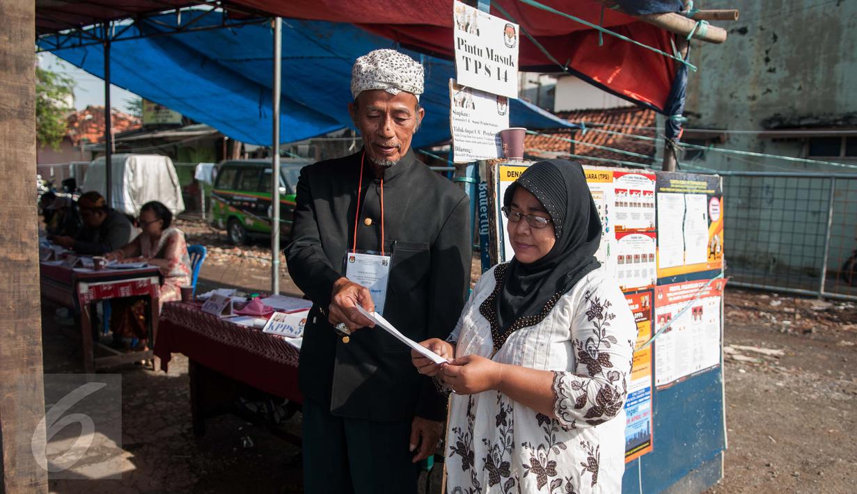 Petugas KPPS mengenakan pakaian adat dan belangkon memberikan pelayanan kepada warga yang menggunakan hak pilih di TPS 14 Cipinang Besar Selatan, Jakarta, Rabu (19/4). (Liputan6.com/Gempur M. Surya)