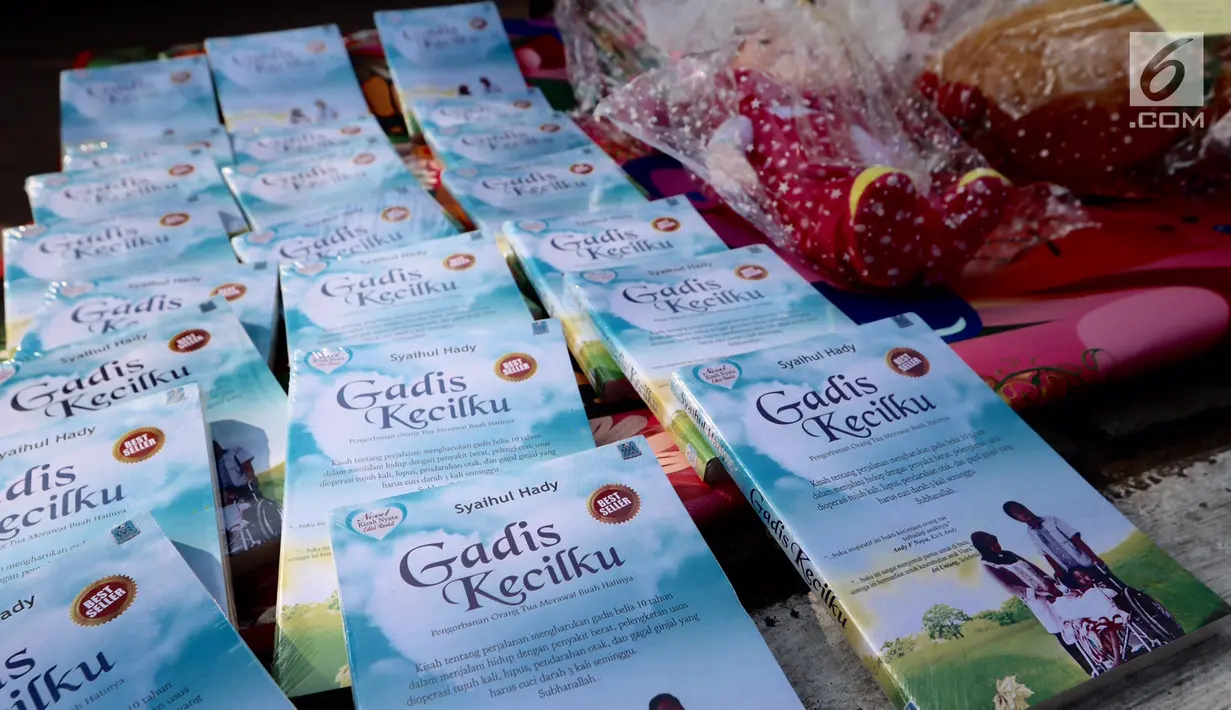 Sejumlah buku berjudul Gadis Kecilku dijual untuk biaya cuci darah dan cangkok ginjal saat Aksi Peduli Viara di kawasan Bundaran HI, Jakarta, Minggu (10/09). Aksi memasuki minggu ke 5 saat Car Free Day. (Liputan6.com/Fery Pradolo)